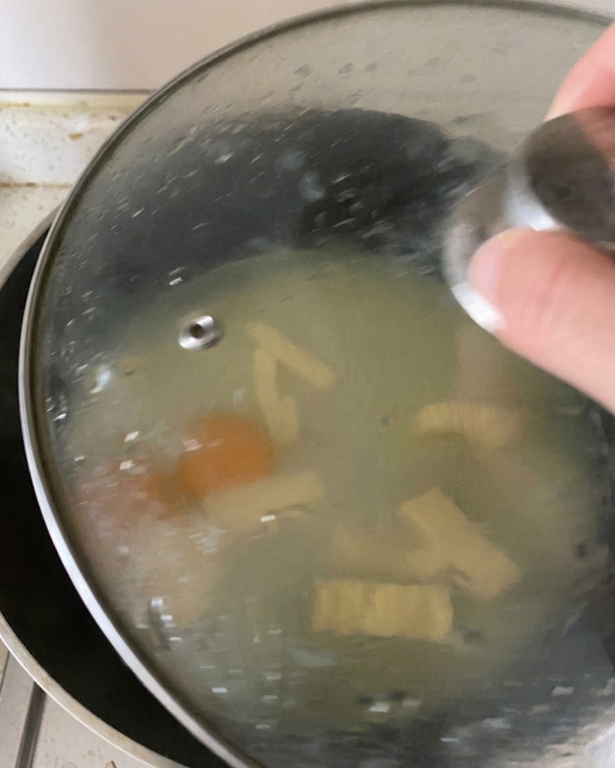 Una tapa de cristal sobre una sartén, reteniendo el vapor en su interior para cocinar los huevos y fundir el queso.
