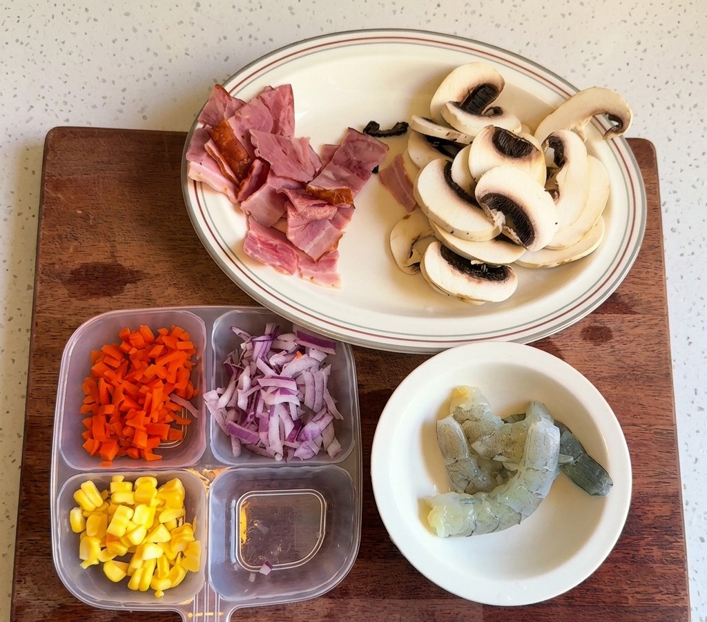 Un recipiente con secciones separadas de zanahoria picada, maíz dulce y cebolla morada picada.