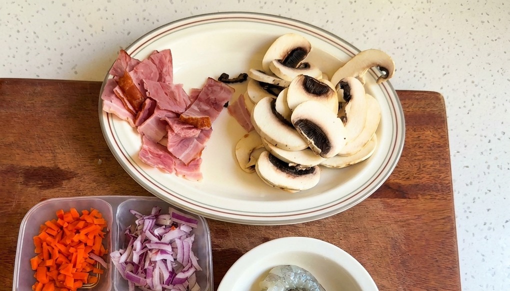 Un plato blanco con champiñones blancos laminados y trozos de tocino picado.
