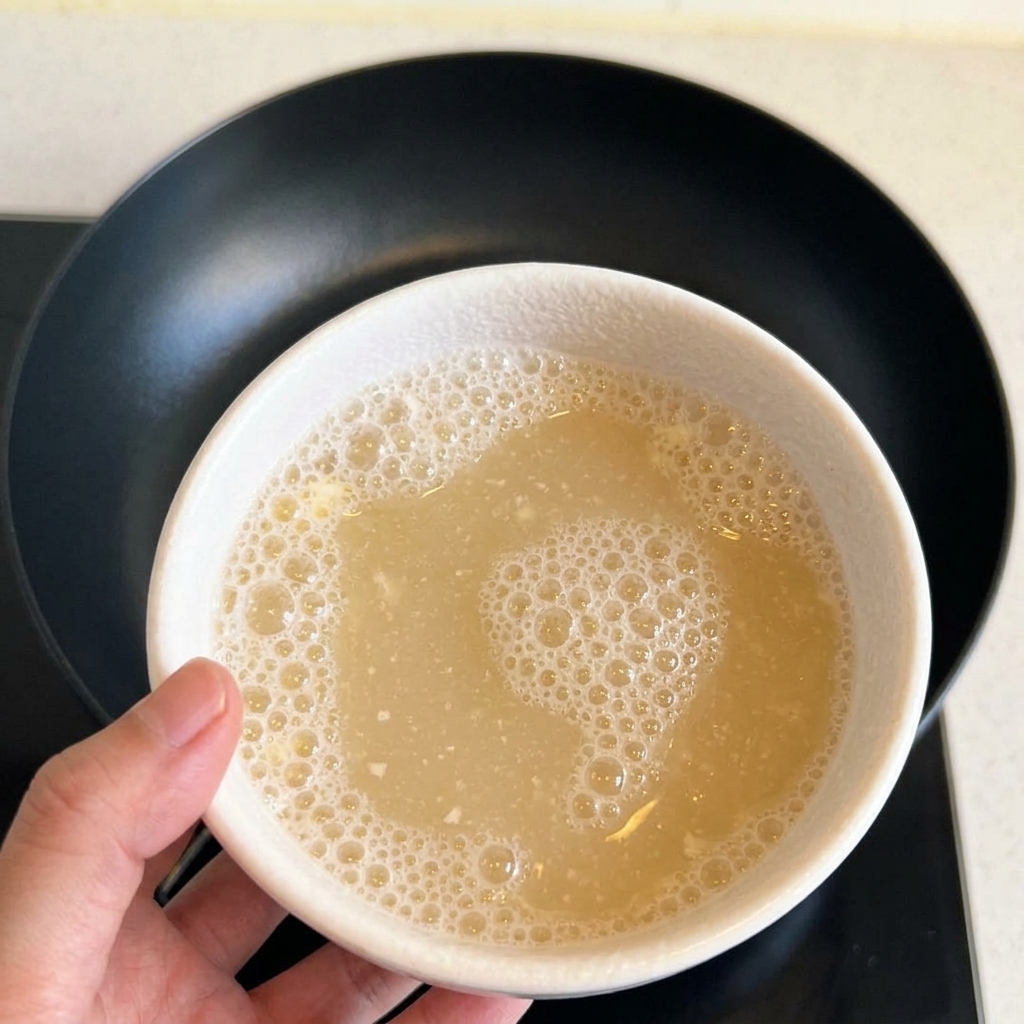 Un bol con una mezcla líquida y espumosa de harina y agua.