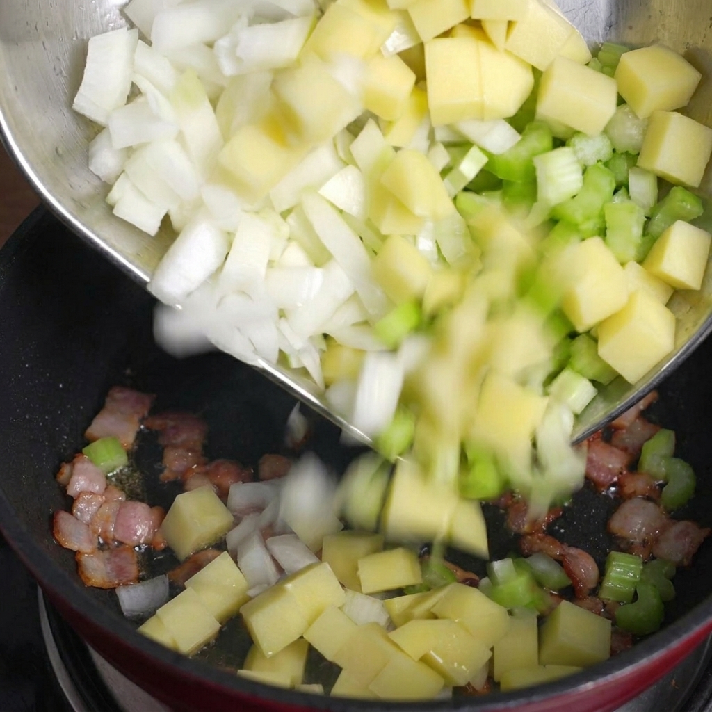 Vertiendo las patatas, el apio y la cebolla en la olla con el bacon dorado.