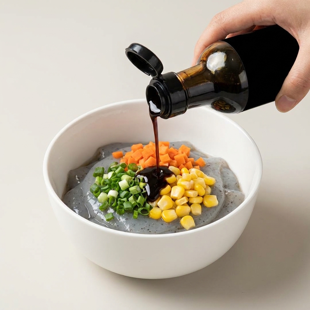 Salsa oscura vertiéndose desde una botella sobre el relleno de gambas y vegetales.