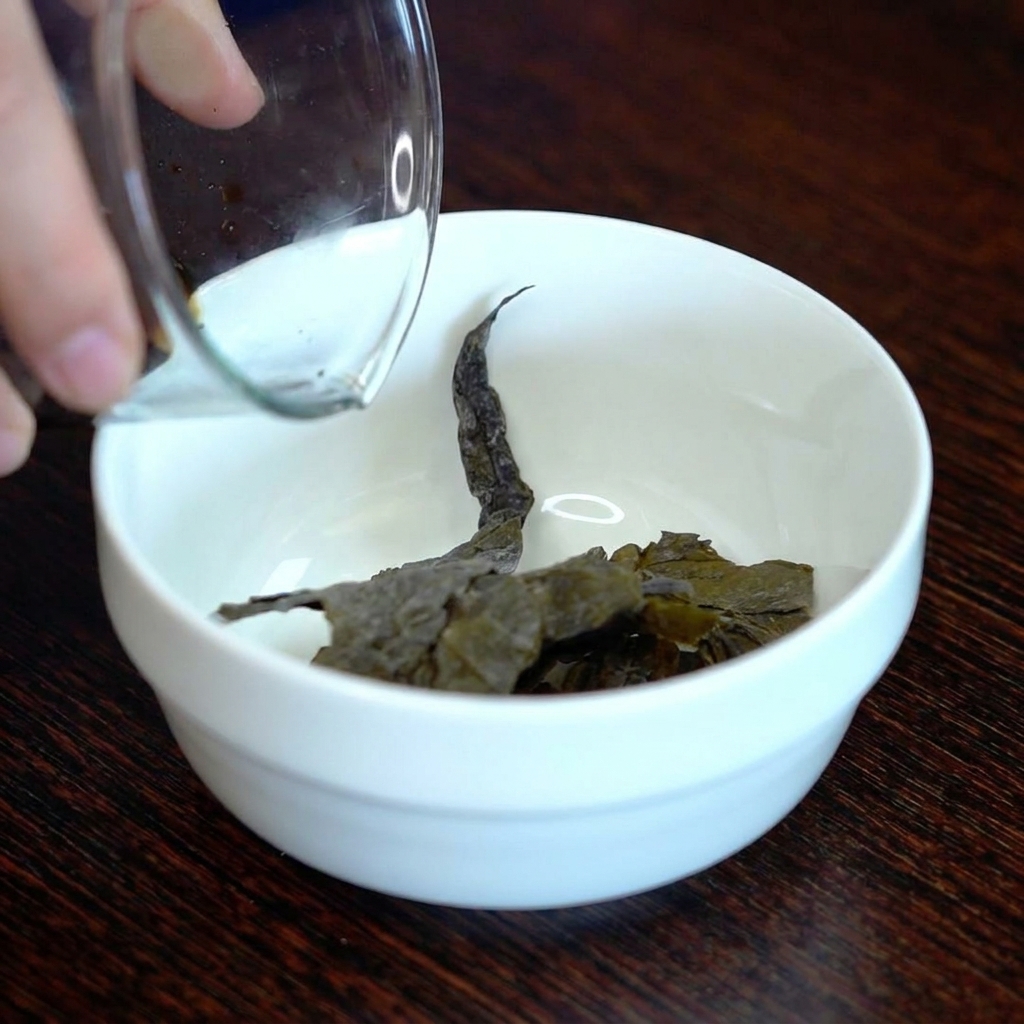 Salsa de soja oscura vertiéndose sobre una pieza de kombu seco en un cuenco de cerámica.