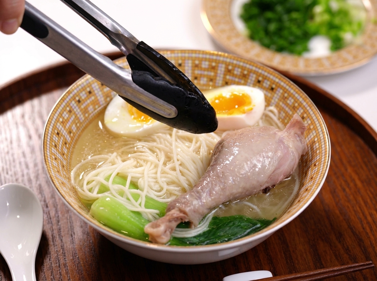 Colocando un muslo de pollo cocido en el bol de sopa con fideos.