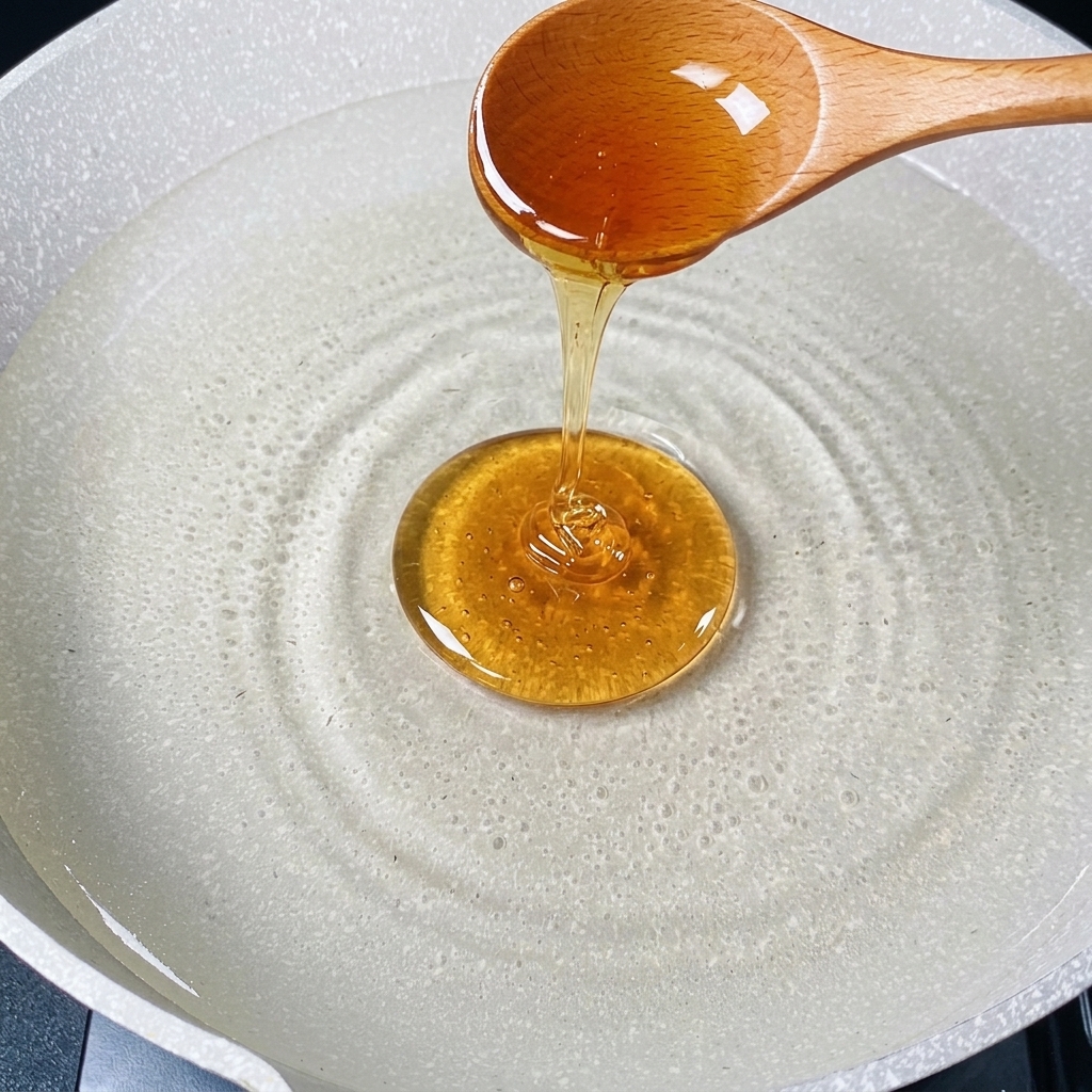 Una cuchara vertiendo aceite de cocina en una olla con agua caliente.