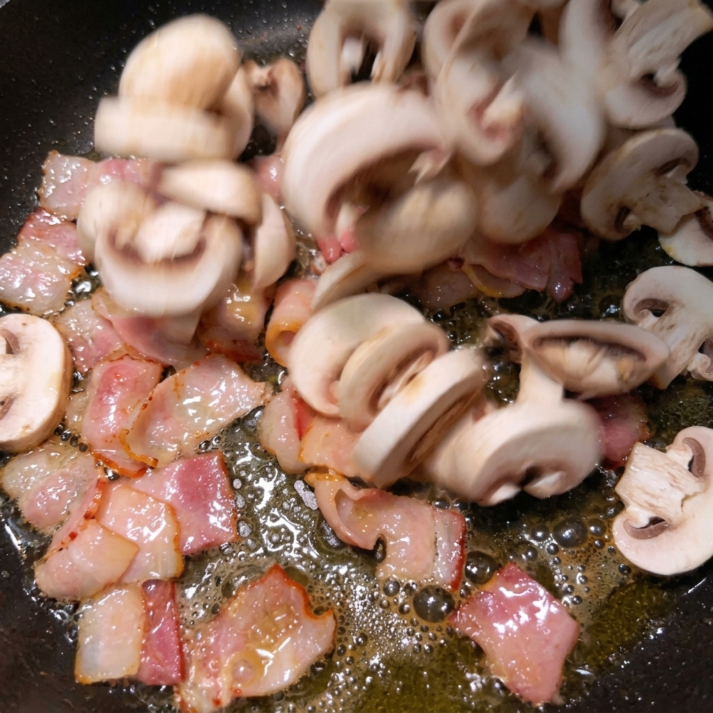 Láminas de champiñones blancos cayendo en una sartén caliente con trozos de bacón crujiente.