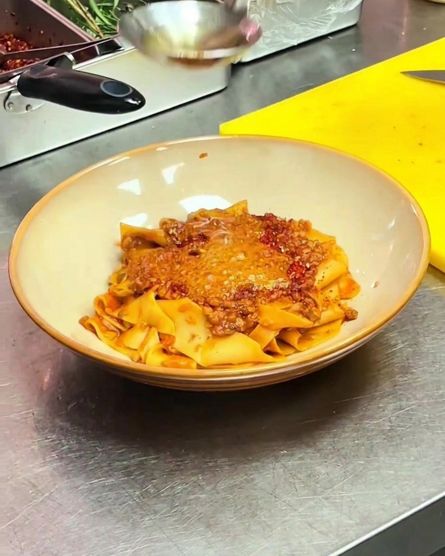 Un huevo poché delicado colocándose en el centro de la pasta con aceite de chile.