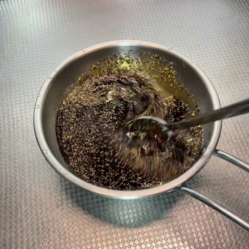 Mezcla de salsa a la pimienta negra siendo removida rápidamente con una cuchara en un bol.