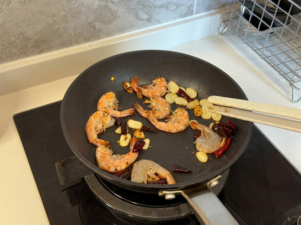 Gambas volviéndose rosadas y doradas mientras se fríen con ajo y guindilla en una sartén.