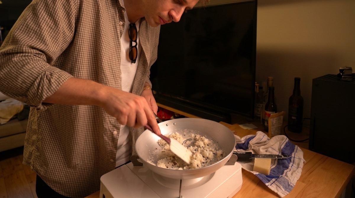 Removiendo el queso Pecorino, agua templada y pimienta negra con una espátula para formar una pasta espesa.