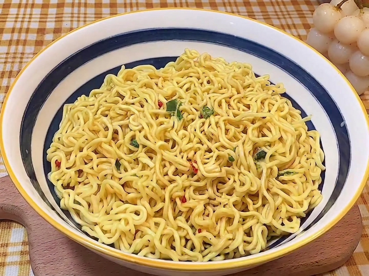 Fideos ondulados dispuestos cuidadosamente en el centro de un bol de cerámica azul y blanco.