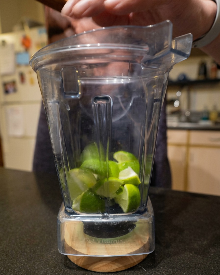 Trozos de lima fresca cortada dentro del vaso de una batidora Vitamix.