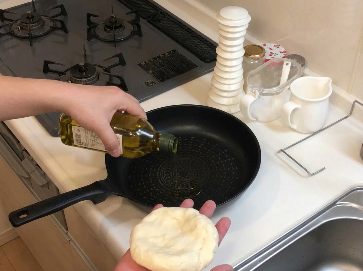 Vertiendo aceite de oliva de una botella verde en una sartén antiadherente negra y fría, mientras se sostiene una porción de masa de pizza en la otra mano.