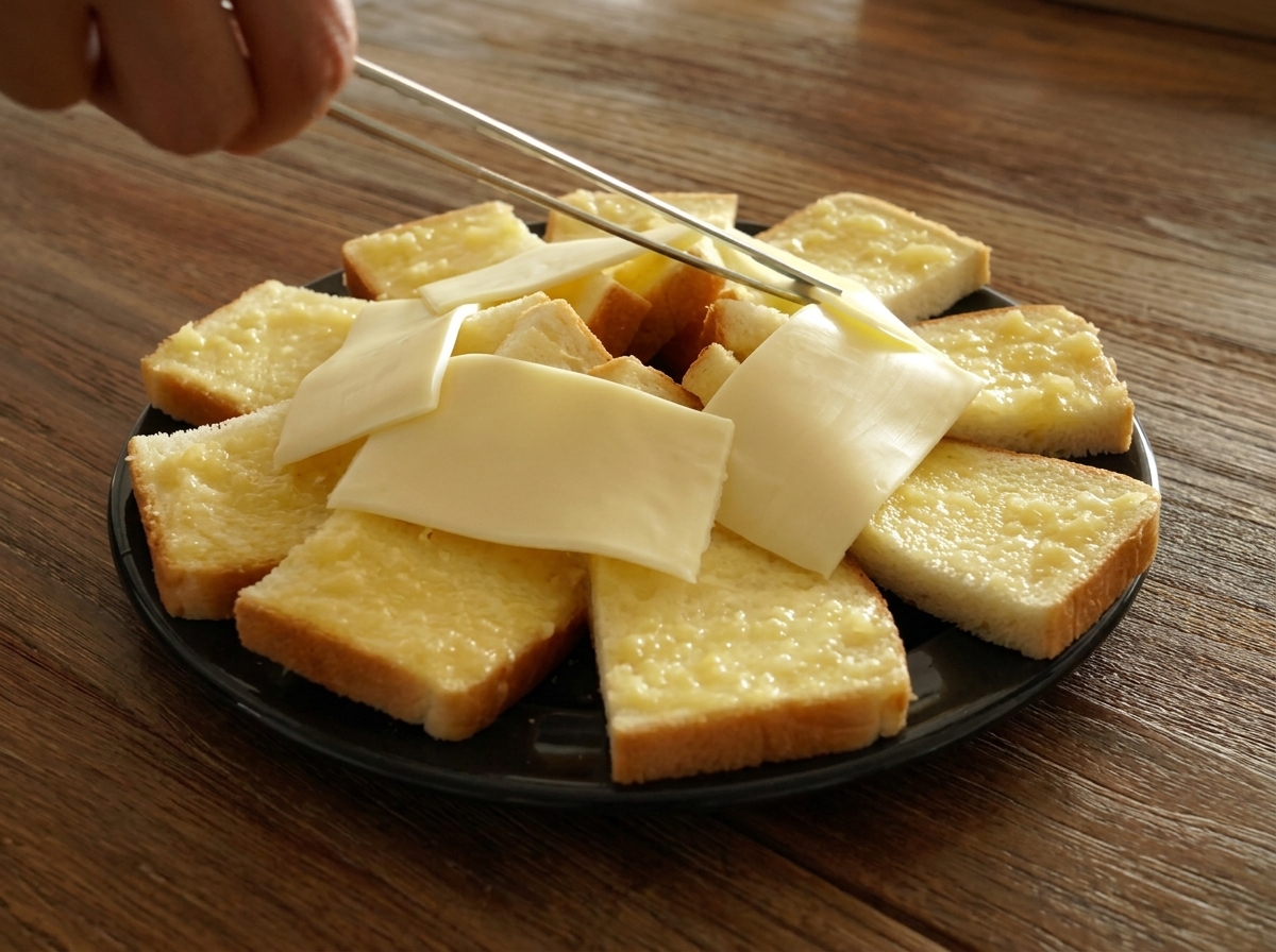 Pinzas colocando lonchas de queso blanco en el centro del anillo de pan.