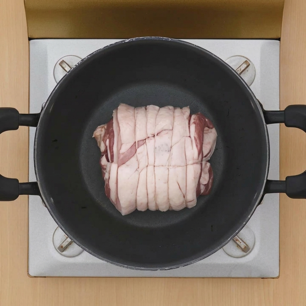 Un rollo de panceta atado en el centro de una olla caliente para comenzar el sellado.