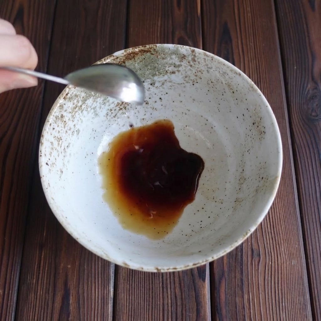 Vertiendo salsa de soja clara en un cuenco de cerámica moteado.
