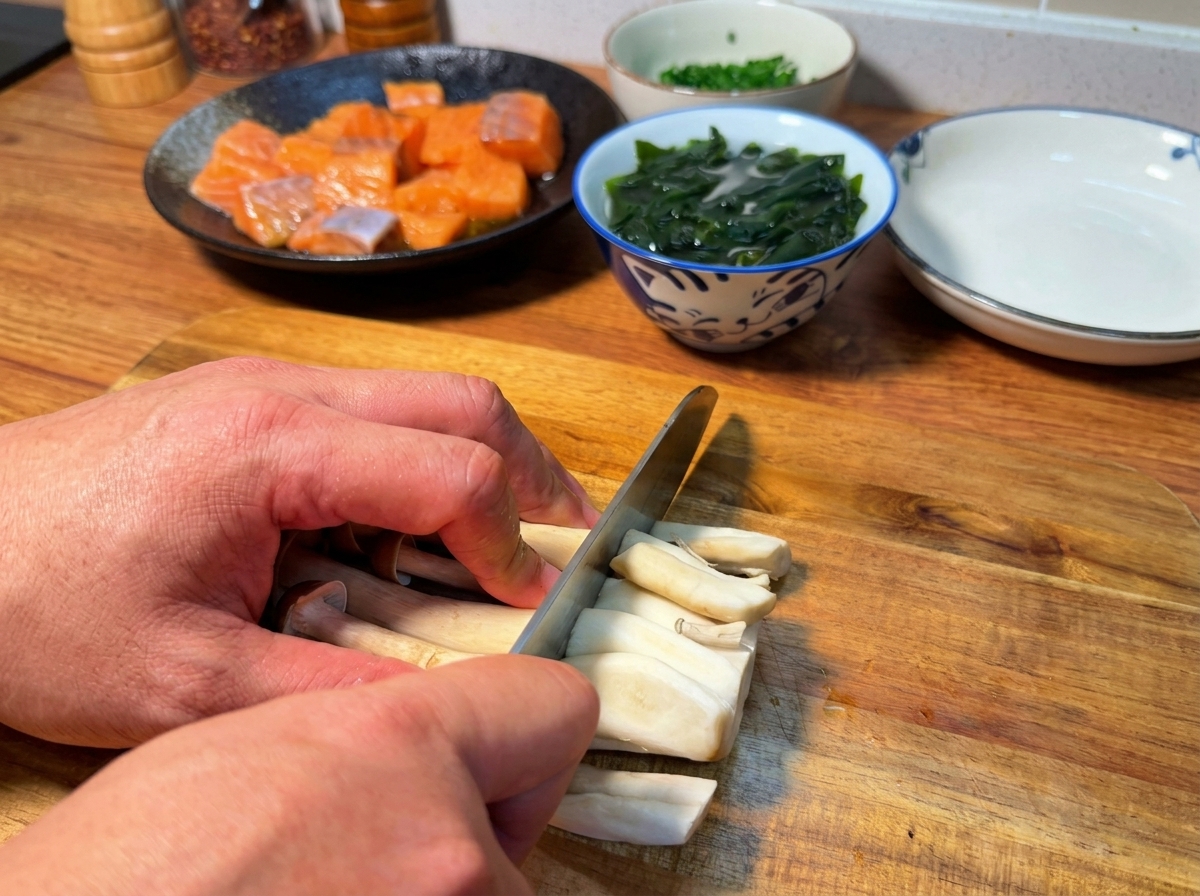 Manos cortando la base de unas setas shimeji marrones sobre una tabla de madera.