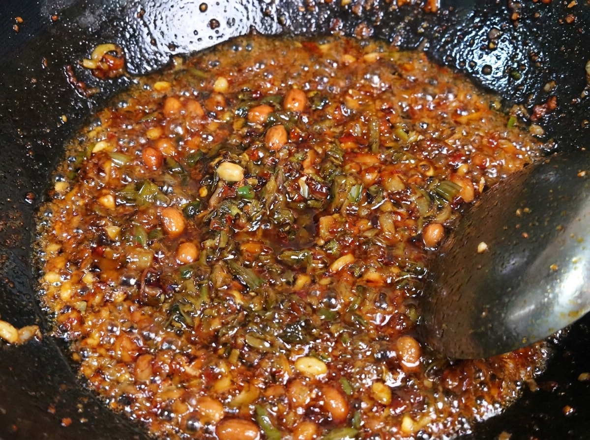 Mezcla de cerdo picado y brotes oscuros de Yibin salteándose juntos en un wok de metal caliente.