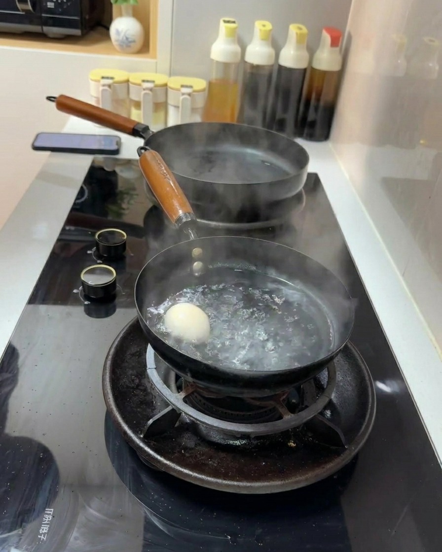 Un huevo blanco sumergido en una pequeña olla con agua hirviendo a borbotones sobre una estufa de gas.