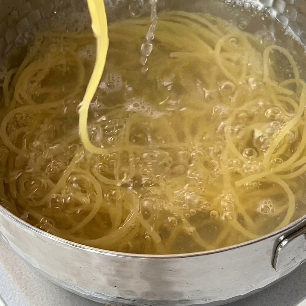 Espaguetis siendo escurridos en un colador dentro del fregadero de la cocina.