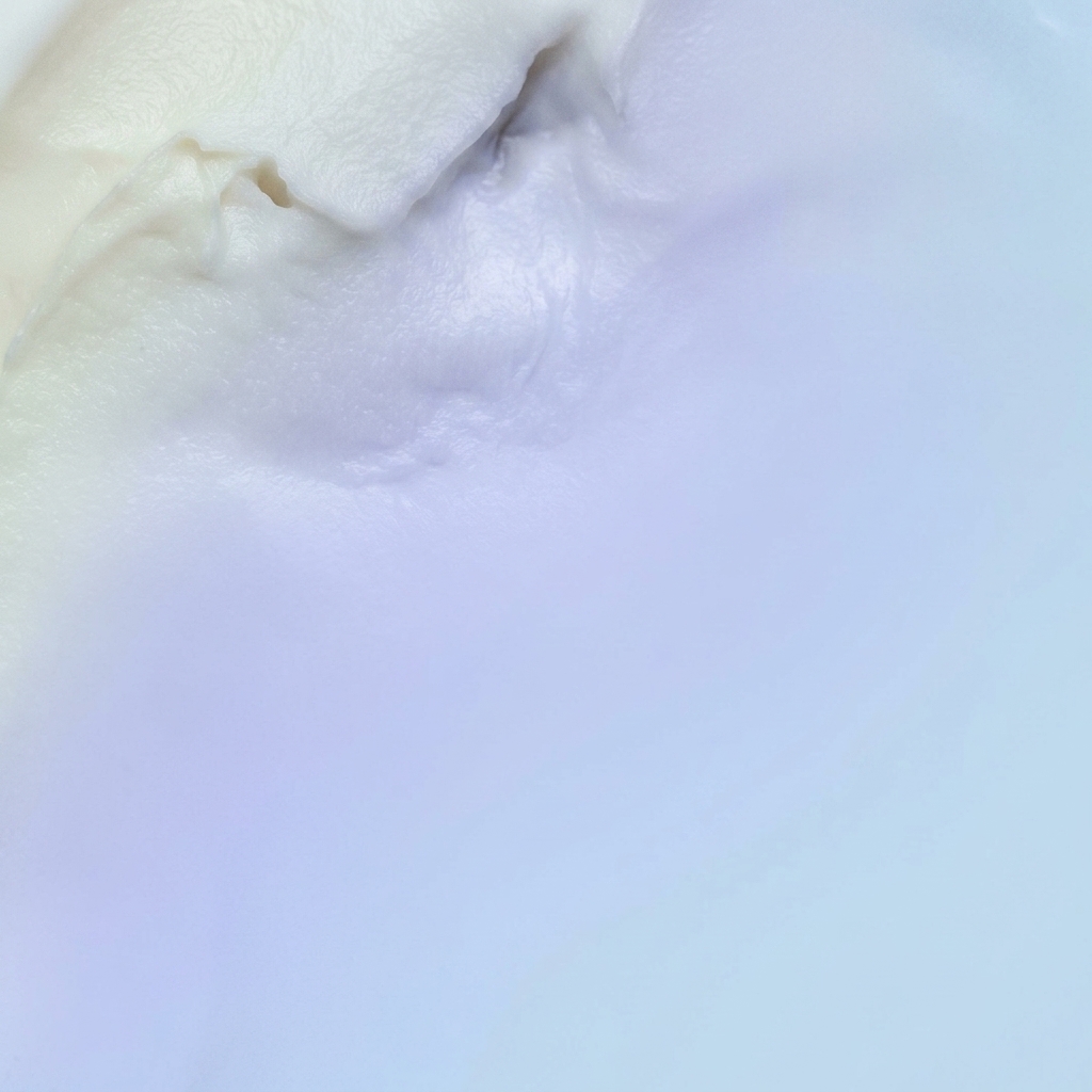 Primer plano de una espátula de madera removiendo una salsa blanca espesa y cremosa en una olla.