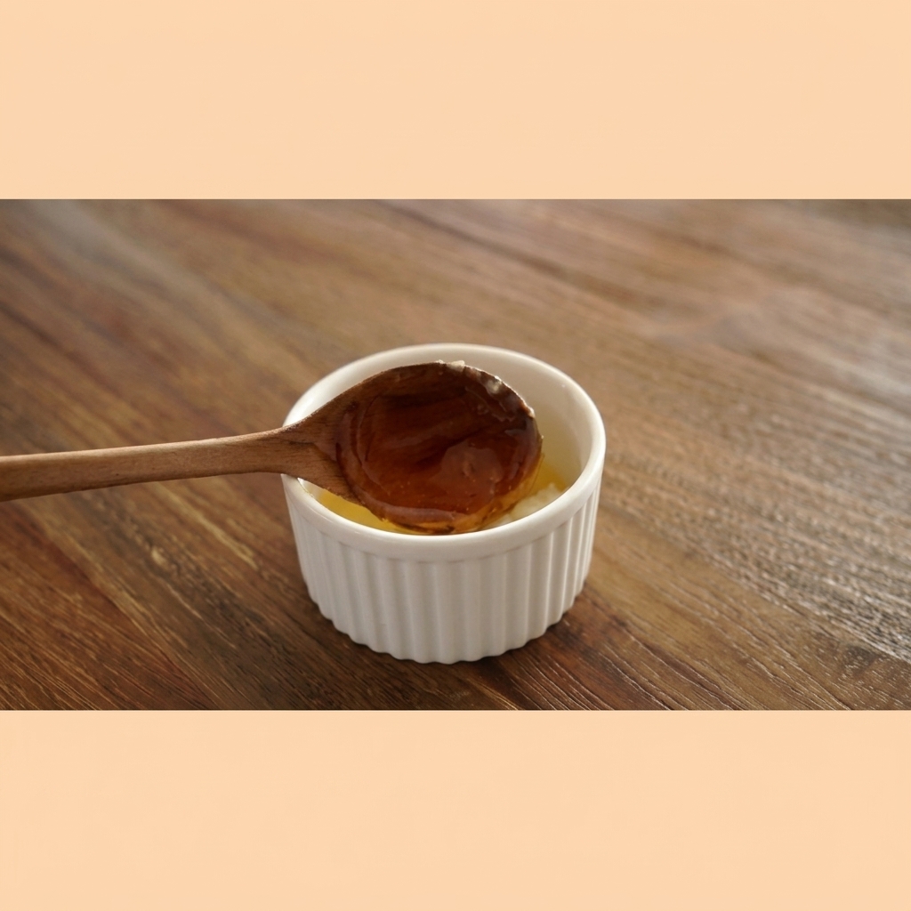 Miel de color ámbar cayendo de una cuchara de madera en un cuenco blanco con mantequilla de ajo.