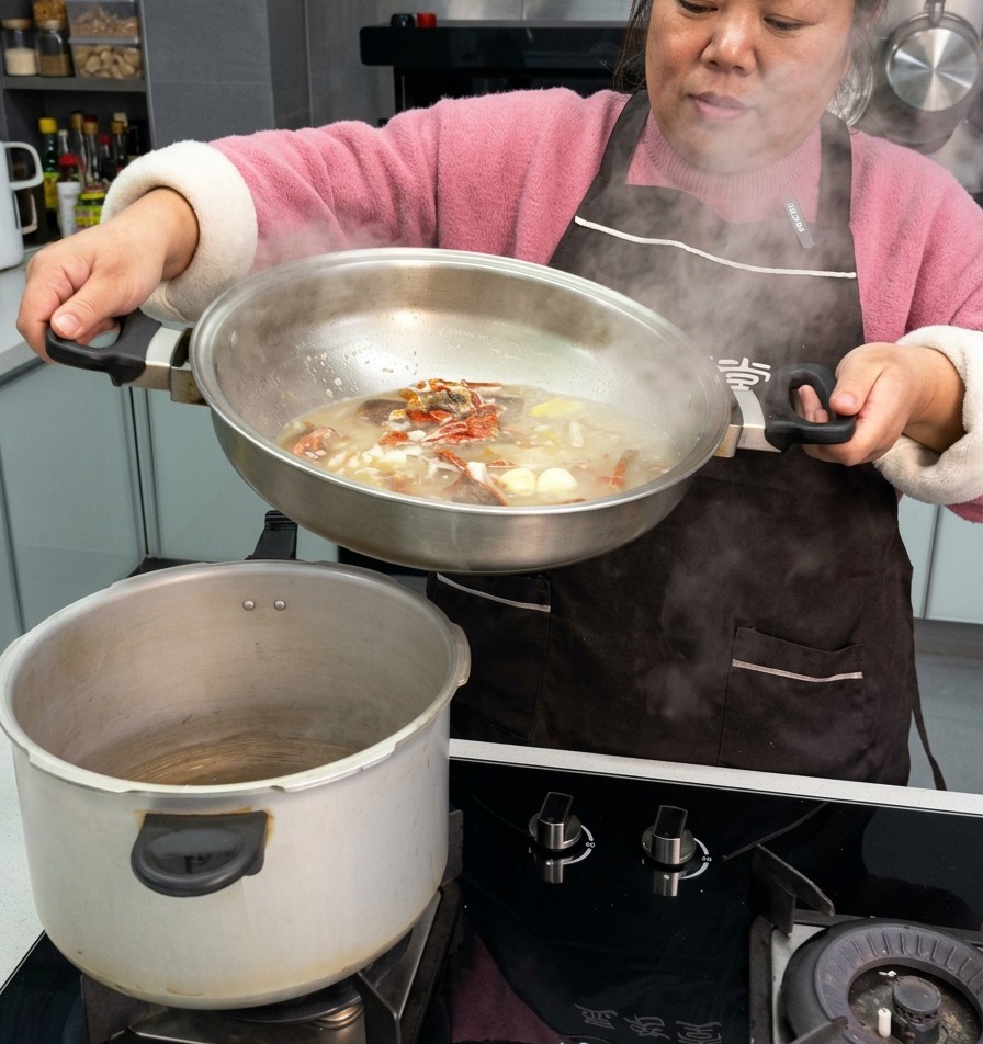 Una persona vertiendo un rico caldo con costillas de cerdo curadas, ajo y chiles secos desde una sartén de acero inoxidable a una olla a presión.