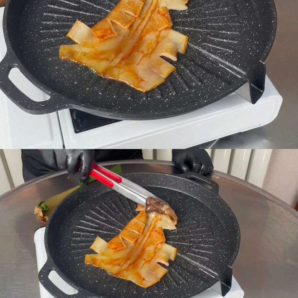 Unas pinzas de metal colocando un calamar marinado entero sobre una parrilla negra estriada y caliente.