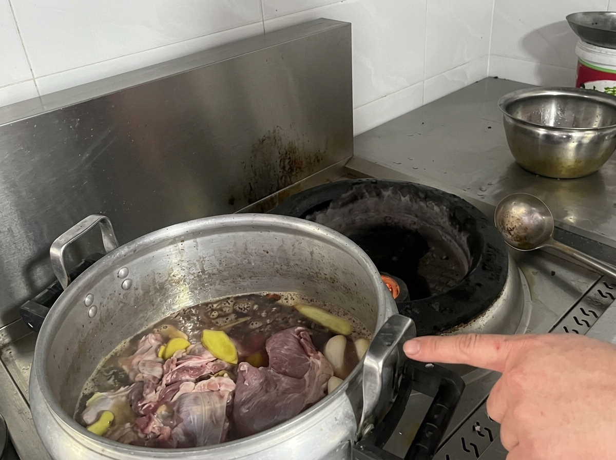 Olla grande con carnes y caldo en la estufa.