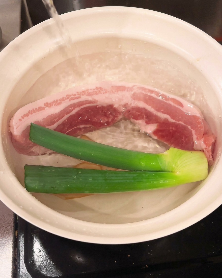 Vino de cocina vertido en la olla, combinándose con la carne y los aromáticos.