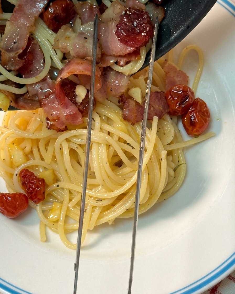Sirviendo la pasta en un plato blanco con borde azul.