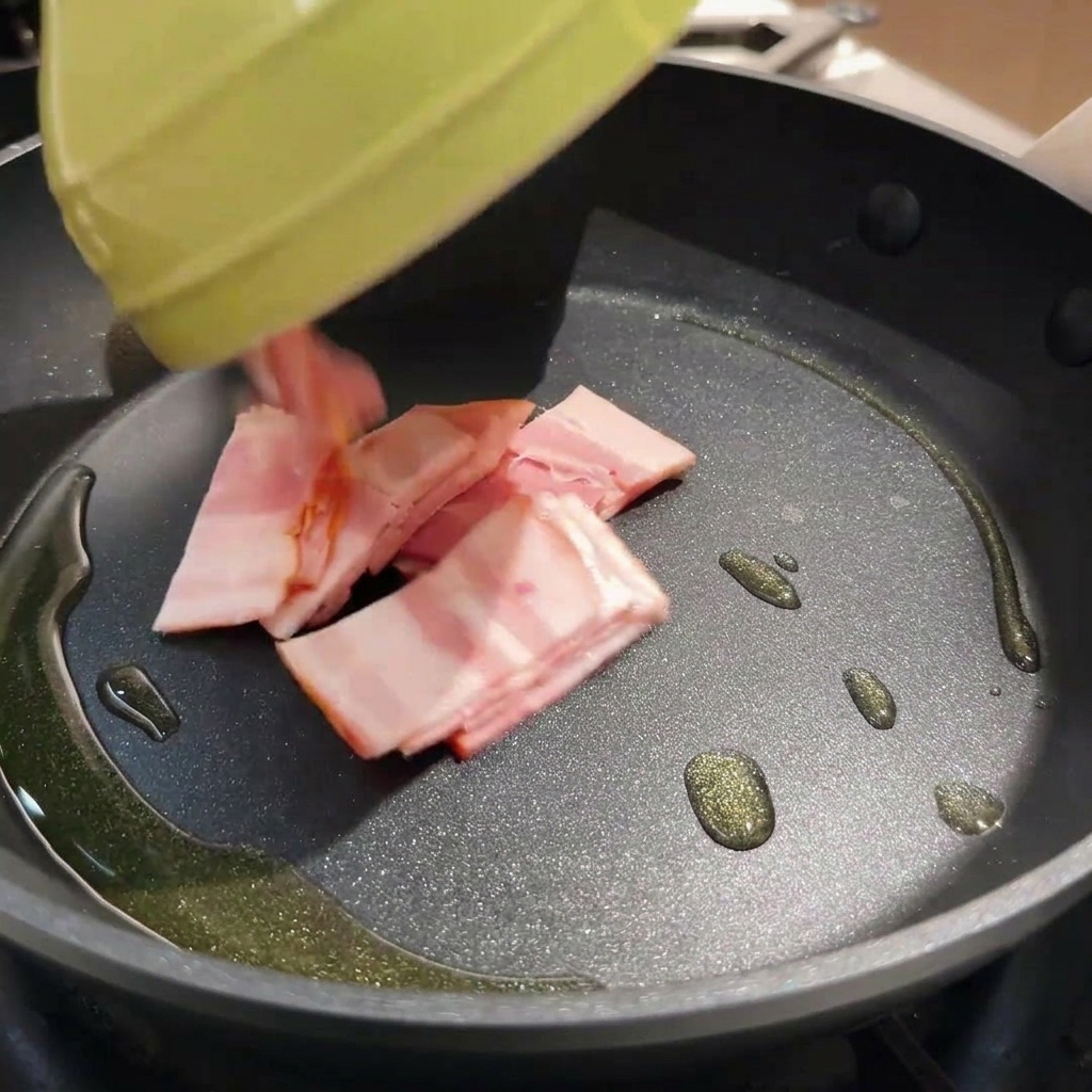 Trozos de tocino crujiente friéndose en una sartén caliente con aceite.