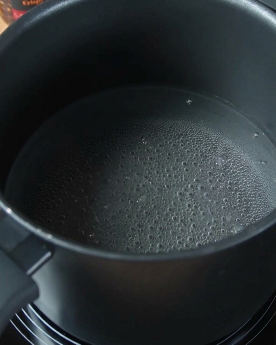 Espaguetis ablandándose en una olla con agua hirviendo.