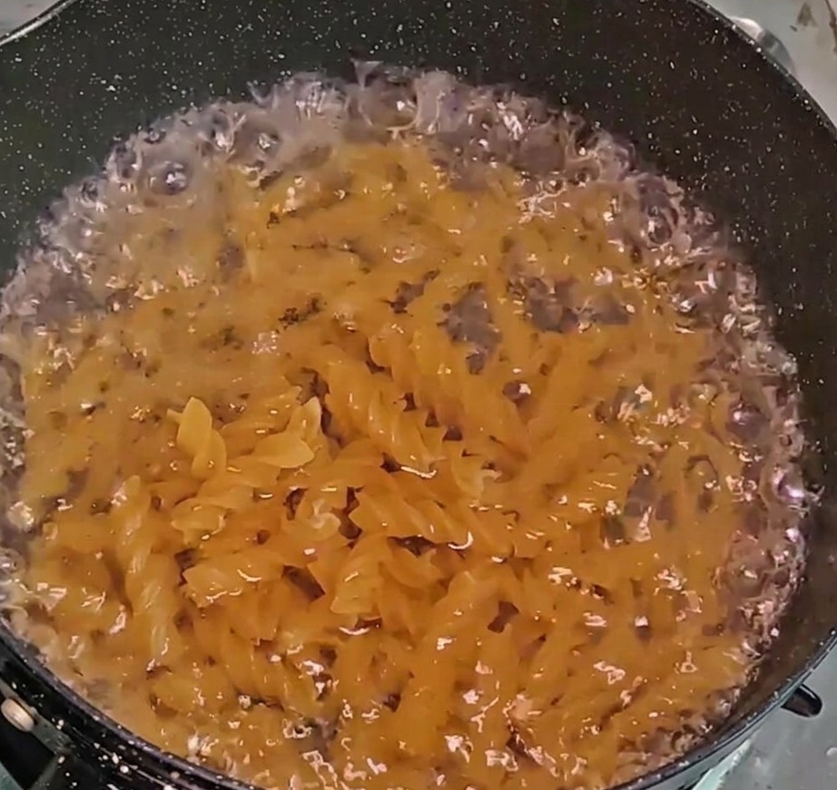 Pasta fusilli cocinándose en una olla de agua burbujeante.