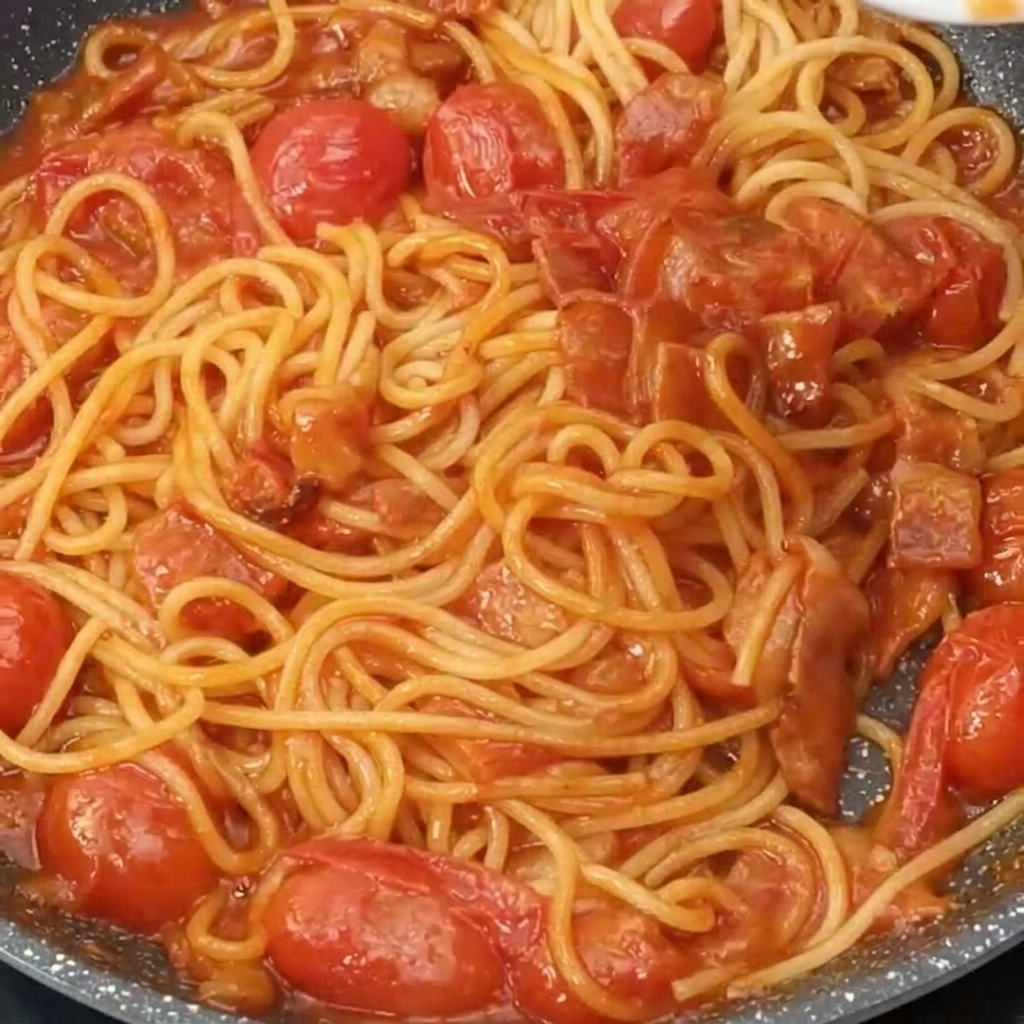 Espaguetis con salsa cubiertos con una capa de queso recién rallado.