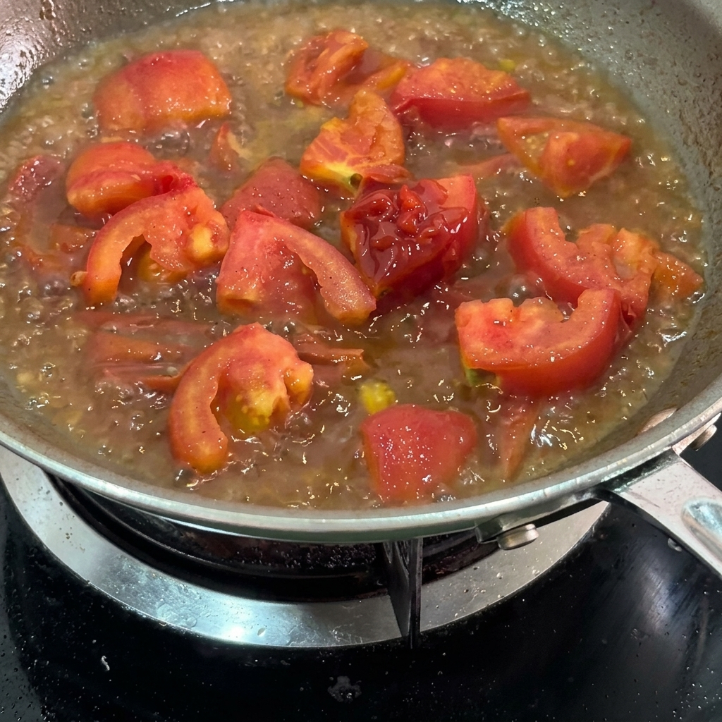 Kétchup mezclándose en la salsa de tomate hirviendo.