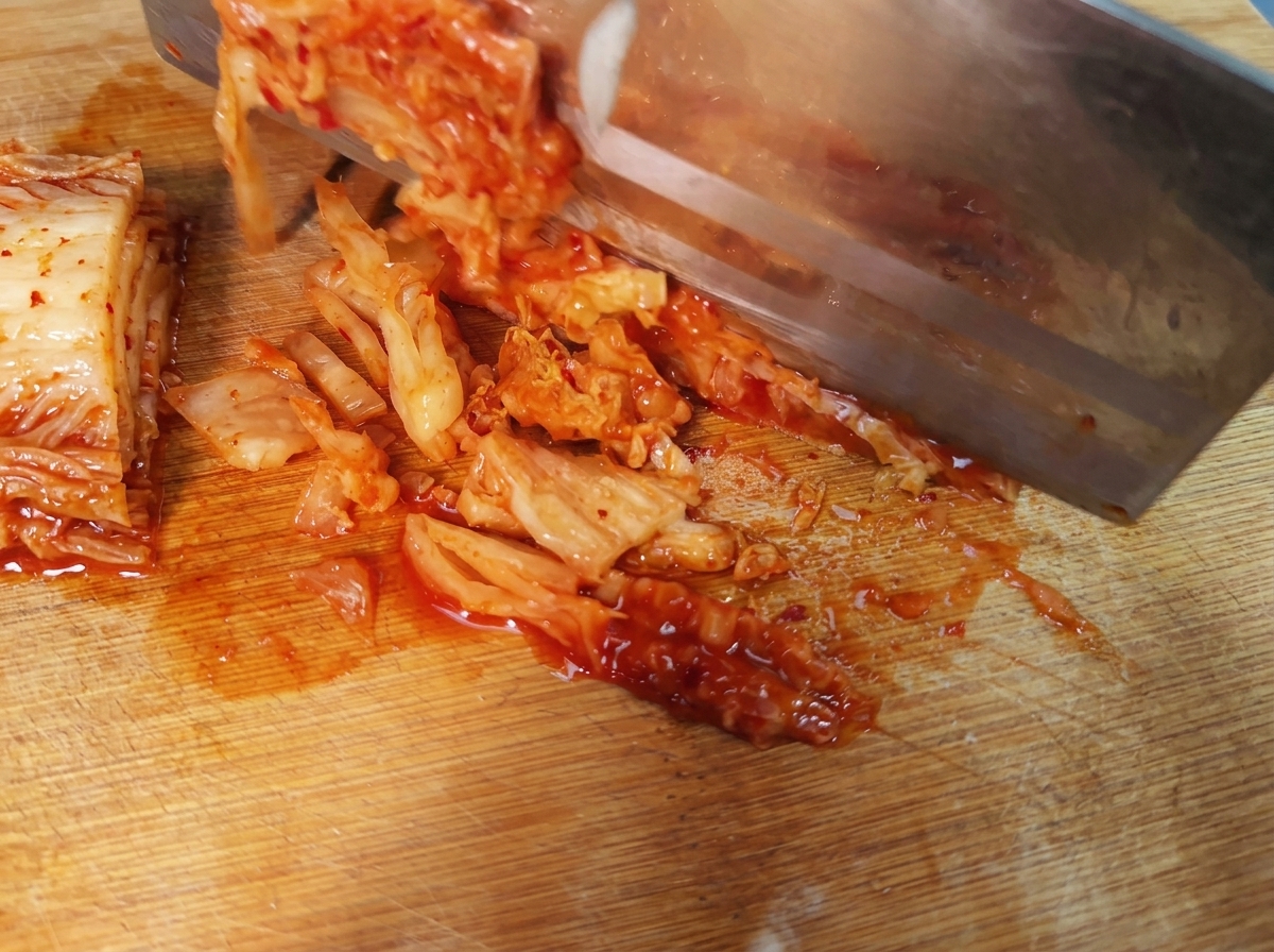 Tiras de kimchi coreano picante dispuestas sobre una tabla de cortar.