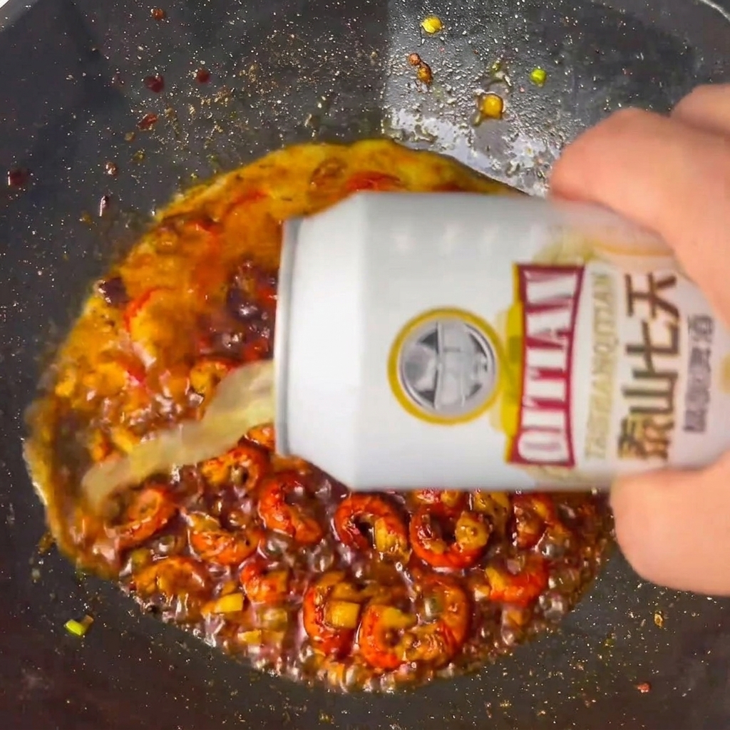 Cerveza vertida en el wok con el cangrejo sazonado.