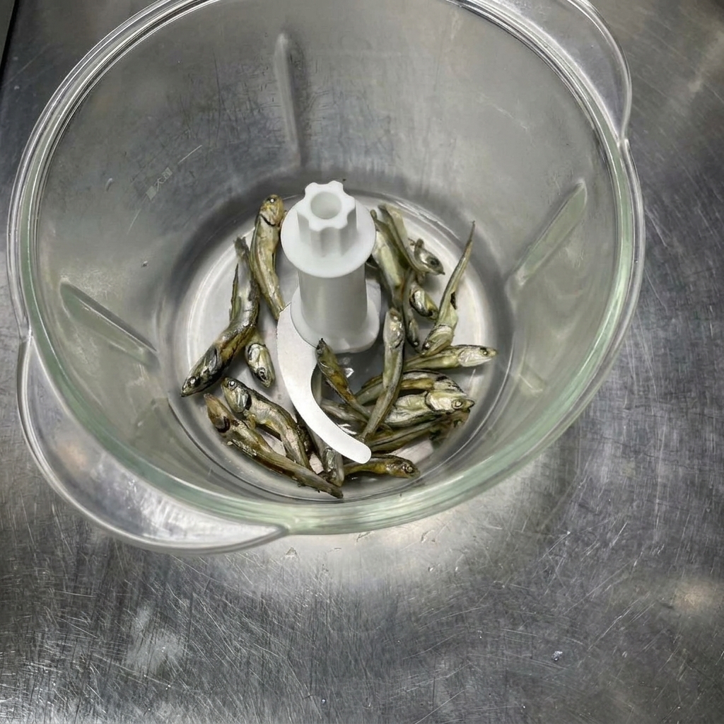 Pescados secos dentro de un procesador de alimentos antes de ser triturados hasta convertirse en polvo.