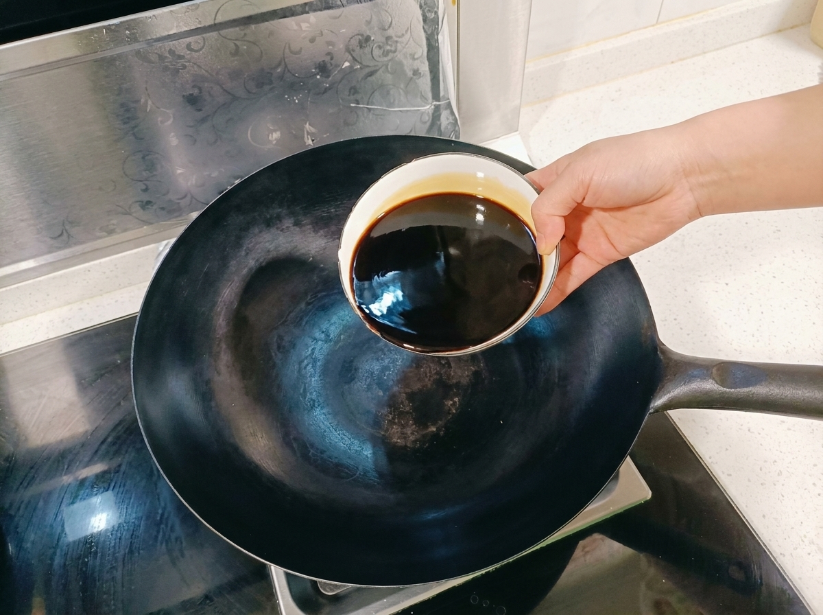 Mezcla de salsa de soja y especias aromáticas hirviendo a fuego lento en un wok.