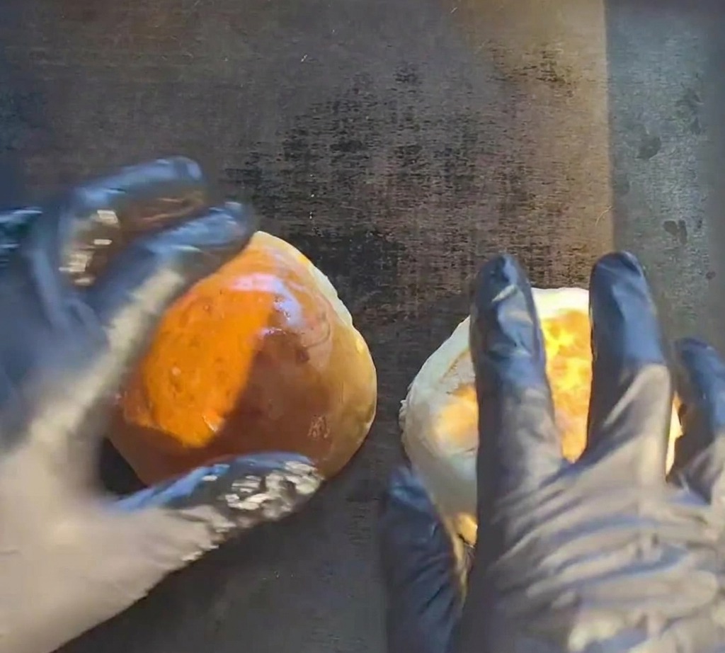Una carne para hamburguesa chisporroteando en una plancha caliente.