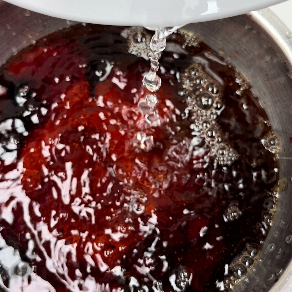 Una porción de mantequilla derritiéndose en una sartén caliente de acero inoxidable.