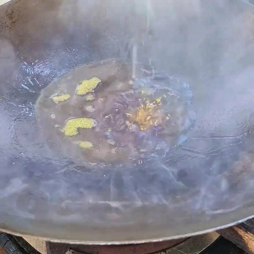 Azúcar blanco derritiéndose y convirtiéndose en un jarabe de caramelo oscuro en aceite caliente dentro de un wok.