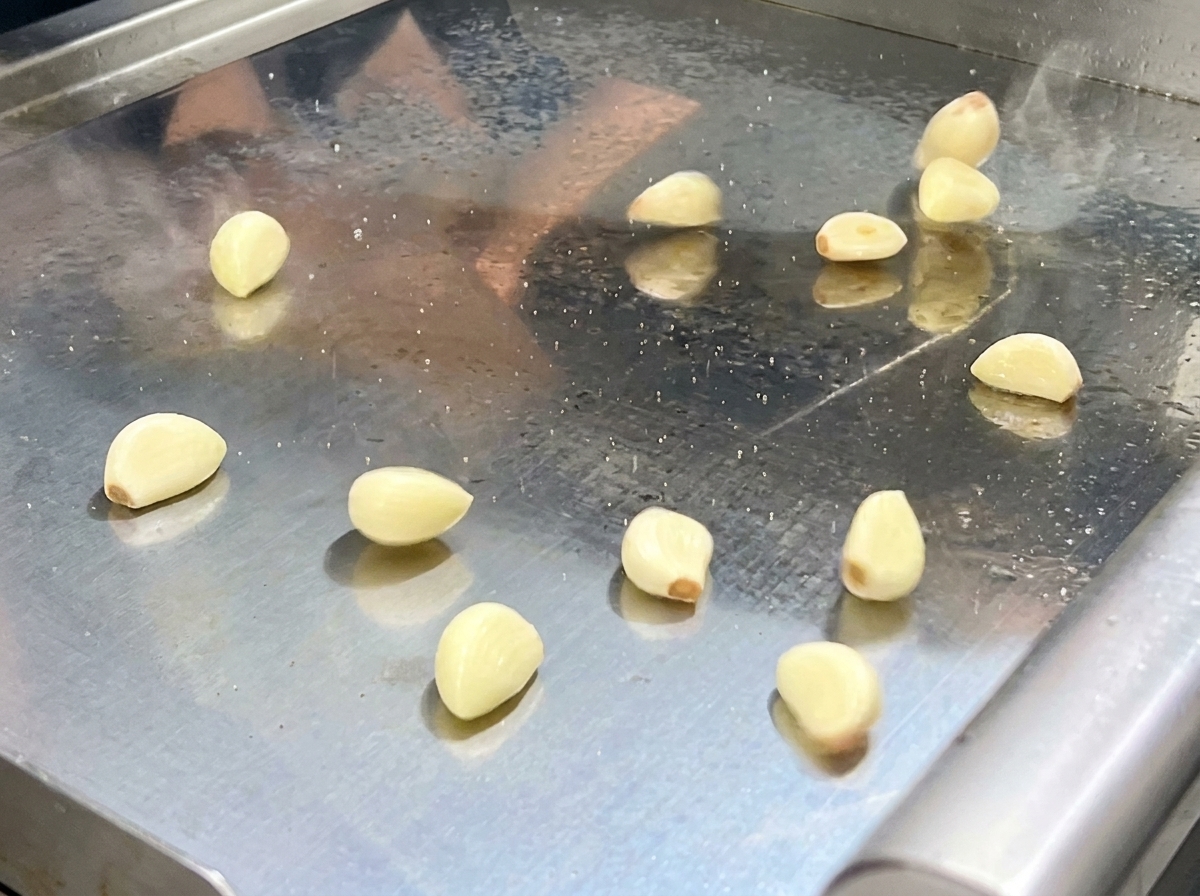 La mezcla salteada de pimientos y aromáticos siendo vertida en el procesador de alimentos.