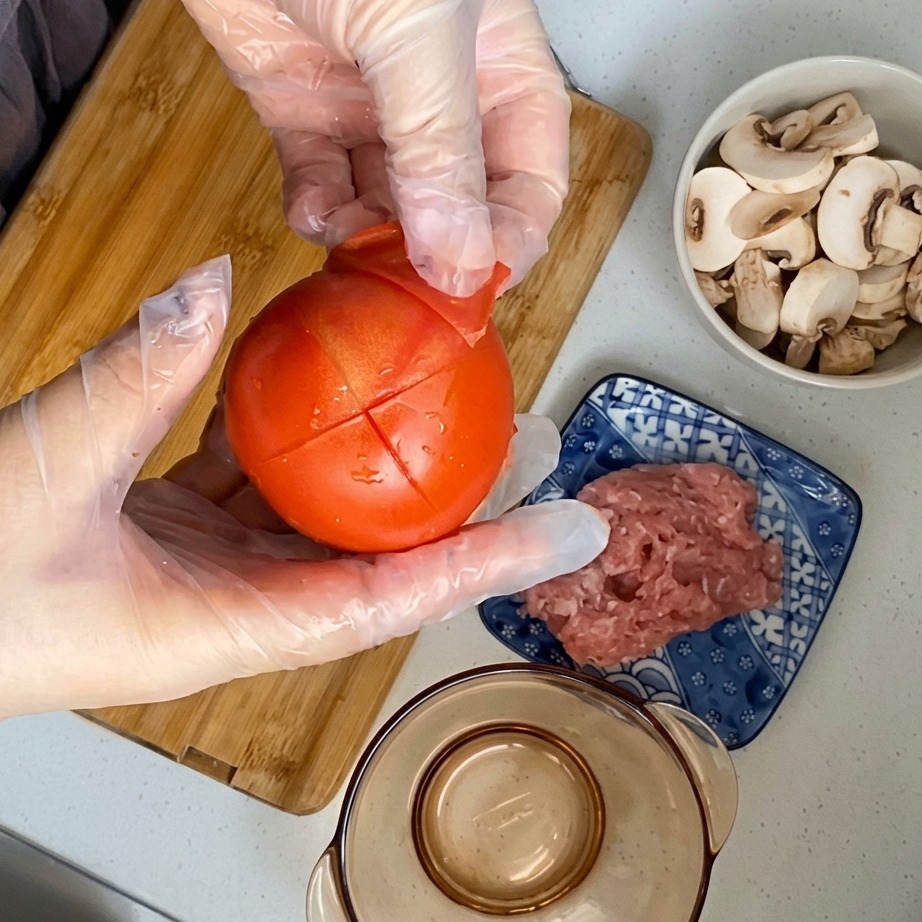 La piel siendo retirada de un tomate blanqueado y marcado.