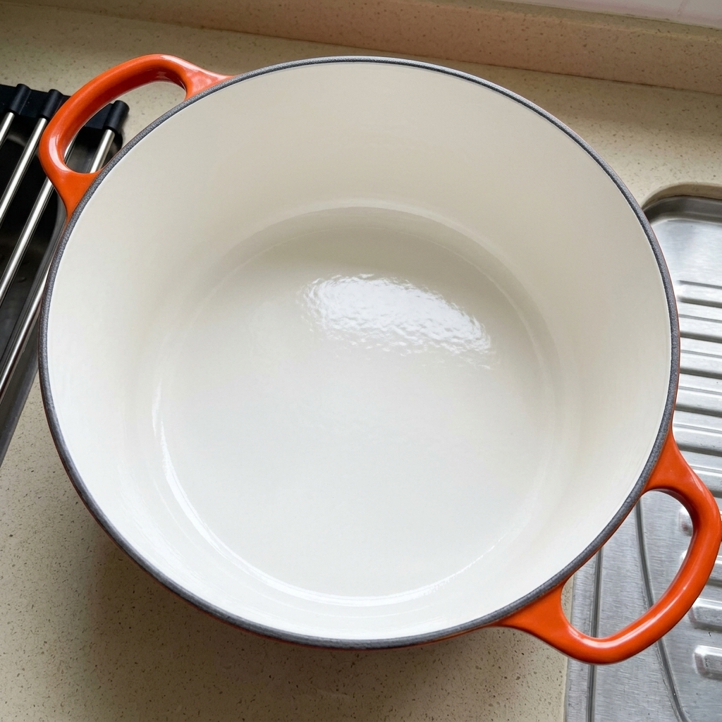 Una cuchara de madera removiendo almejas cubiertas con una pasta espesa roja dentro de una olla.