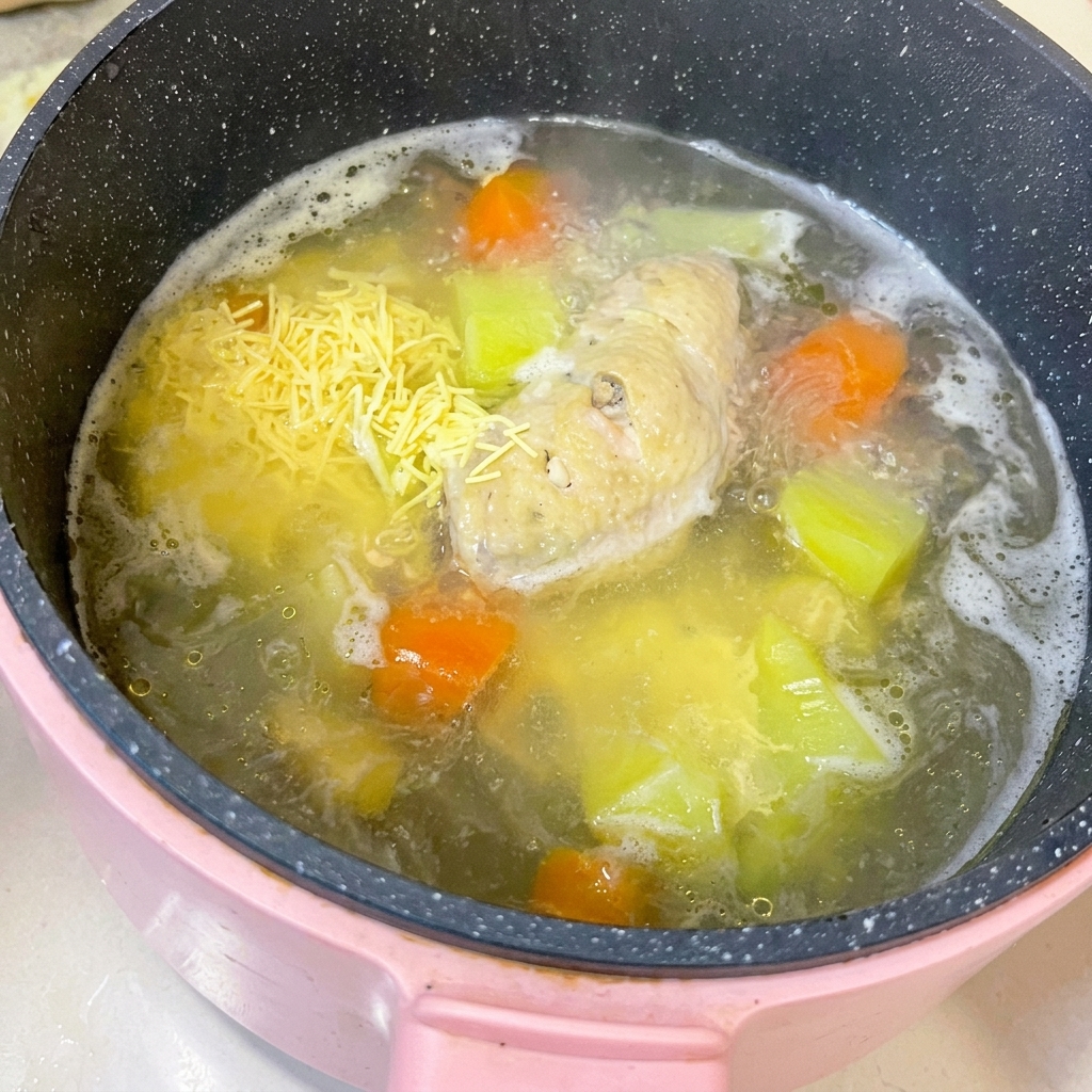 Alitas de pollo cocidas sobre una tabla de cortar con la carne siendo separada del hueso usando un cuchillo de cocina.