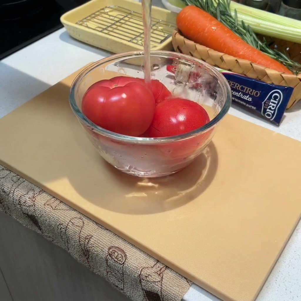 Primer plano de tomates enteros en un bol cubiertos con agua caliente.