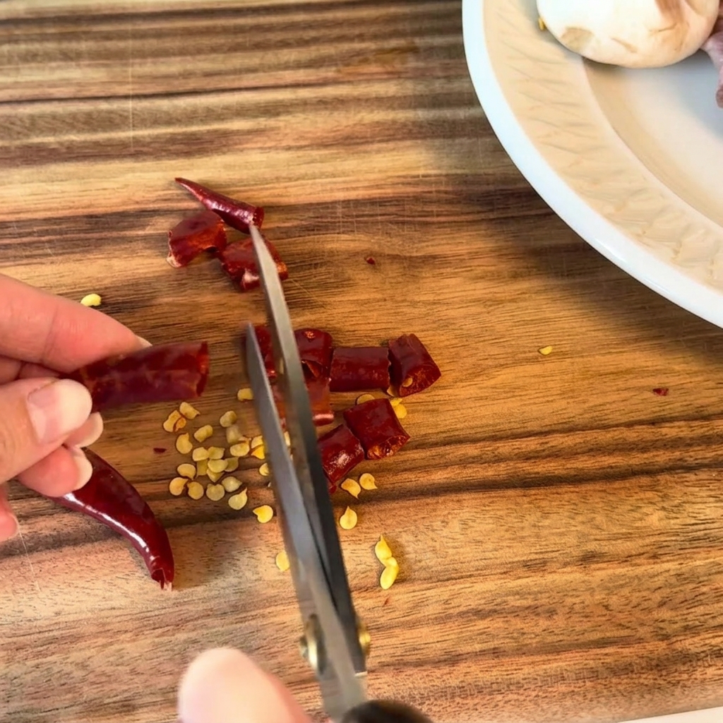 Chiles secos cortados en trozos pequeños con tijeras de cocina.