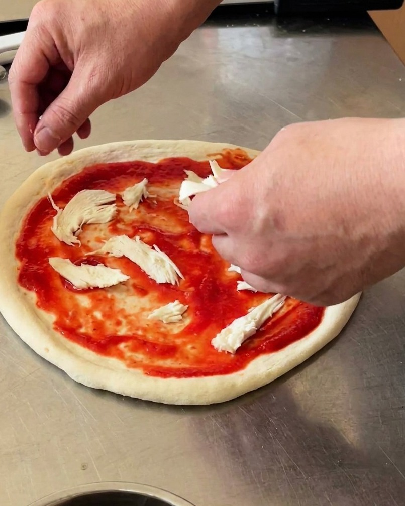 Pizza con trozos de mozzarella de búfala y hojas de albahaca fresca.